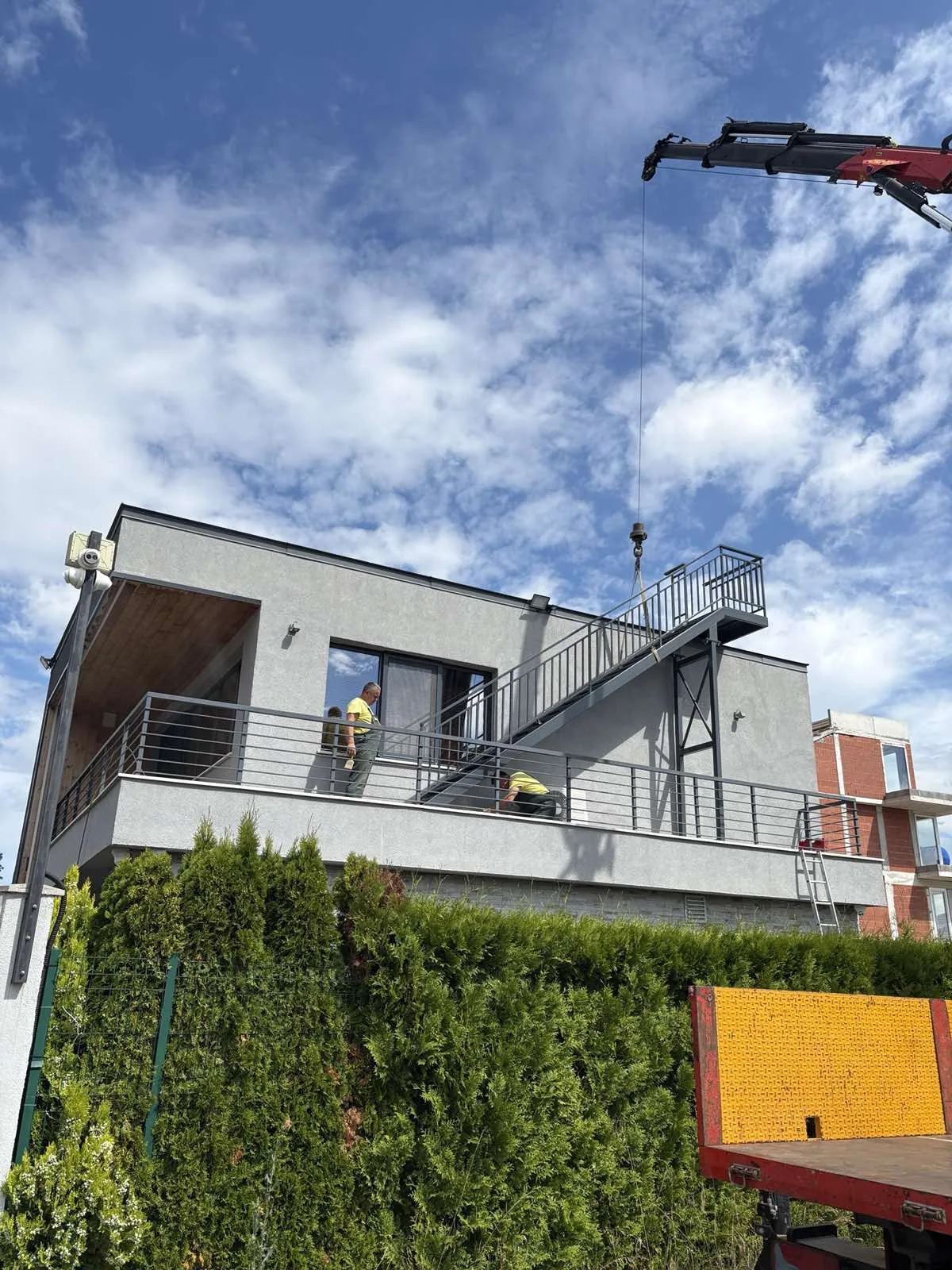 Montage à la grue d'un escalier extérieur sur une villa